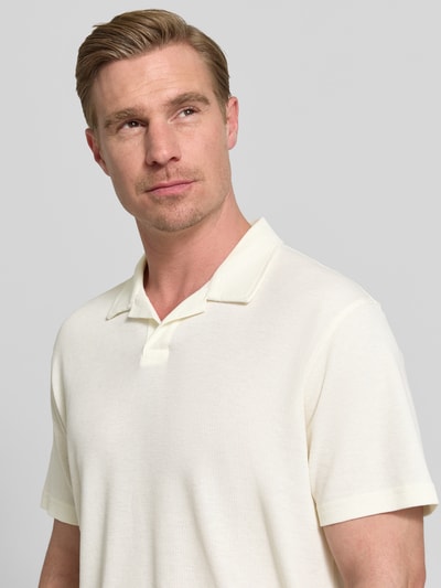 Männermodel trägt Relaxed Fit Poloshirt aus Baumwoll-Mix von Tom Tailor Denim in Optik: Unifarben, Struktur: Piqué, Nahaufnahme Oberkörper.