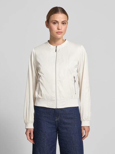 Frauenmodel trägt Jacke mit Rundhalsausschnitt und Reißverschlusstaschen von monari in Weiß, Regular-Fit, Ganzkörperansicht von vorne, Rückenlänge bei Größe 36: 52 cm, Schulterbreite: 46 cm, Brustweite: 53 cm, Ärmellänge: 57 cm.