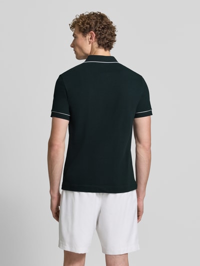 Männermodel trägt dunkelgrünes Regular Fit Poloshirt aus Baumwoll-Mix Modell 'CHEMISE' von Lacoste, Herren Poloshirt, Ganzkörperansicht Rückansicht