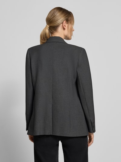 Frauenmodel trägt Blazer mit Viskose-Anteil Modell 'Bergen' von MANGO in Dunkelgrau, strukturierte Oberfläche, Ganzkörperansicht Rückansicht.