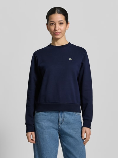 Frauenmodel trägt Relaxed Fit Sweatshirt aus reiner Baumwolle von Lacoste Sport, Optik: Unifarben, Logo-Stitching, Ganzkörperansicht von vorne.