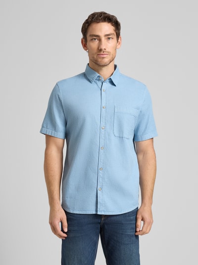 Männermodel trägt Regular Fit Freizeithemd aus reiner Baumwolle von Tom Tailor in Hellblau, Kentkragen, kurzarm, Strukturmuster, Ganzkörperansicht von vorne.