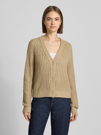 Frauenmodel trägt Relaxed Fit Cardigan in Strick-Optik Modell 'CHARLIE' von NOISY MAY®, beigefarben, grobmaschige Textur, Ganzkörperansicht von vorne. Rückenlänge und Ärmellänge bei Größe S, V-Ausschnitt, legere Passform.