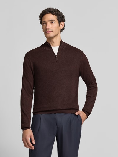 Męski model nosi Slim Fit Strickpullover aus Baumwoll-Mix mit Viskose-Anteil von ROY ROBSON w kroju slim fit, struktura dzianinowa, kolor brązowy, stójka z zamkiem, długie rękawy, ściągacze, logo, długość tyłu w rozmiarze M: 69 cm, długość rękawa: 72 cm, ujęcie całej sylwetki z przodu.