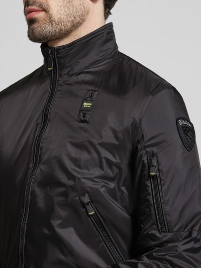 Männermodel trägt Jacke mit Reißverschlusstaschen Modell 'Brahms' von Blauer Usa in Schwarz, glatte Textur, Nahaufnahme Oberkörper