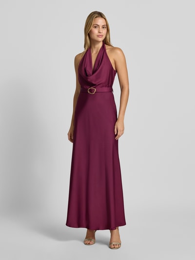 Frauenmodel trägt Abendkleid mit Neckholder von Rinascimento in dunklem Lila, Material-Mix mit Stretch, tailliert, Stoffgürtel, Maxikleid, Ganzkörperansicht von vorne.