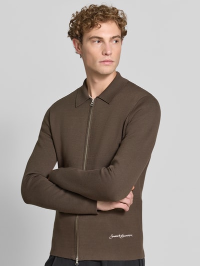 Męski model nosi Regular Fit Jacke aus Viskose-Mix Modell 'Matt' von Samsøe Samsøe w kolorze brązowym, wyhaftowane logo, kołnierzyk polo, zamek błyskawiczny dwustronny, Długość tyłu w rozmiarze M: 70 cm, Długość rękawów w rozmiarze M: 68 cm, mieszanka wiskozy, Ganzkörperansicht von vorne