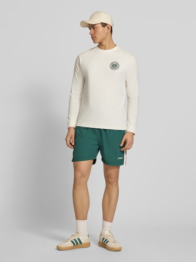 Männermodel trägt Shorts mit Label-Stitching Modell 'Slipstream' von PROHIBITED in Grün, elastischer Bund, Regular Fit, Ganzkörperansicht von vorne.