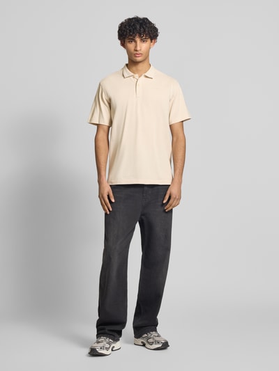 Männermodel trägt Regular Fit Poloshirt aus reiner Baumwolle Modell 'Core' von G-Star Raw in Beige, Ganzkörperansicht von vorne.