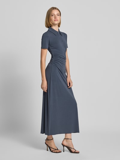 Frauenmodel trägt Polokleid mit Knopfleiste Modell 'SUN' von Samsøe Samsøe in Blau, figurbetont, Maxikleid, glatte Textur, Ganzkörperansicht von vorne. Modal-Mix mit Stretch-Anteil.