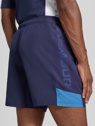 Mannenmodel draagt donkerblauwe Regular Fit Sportshorts met elastische band model 'UTILITY' van Under Armour, detailopname schuin van achteren, Heren Sportshorts van Under Armour.