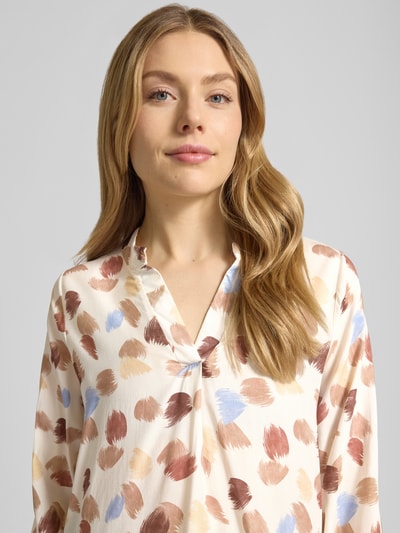 Frauenmodel trägt Regular Fit Bluse aus reiner Viskose Modell 'Hilga' von ZABAIONE, cremefarben mit Muster, Nahaufnahme Oberkörper. Tunika-Kragen, lange Ärmel mit elastischen Abschlüssen, weiche Textur
