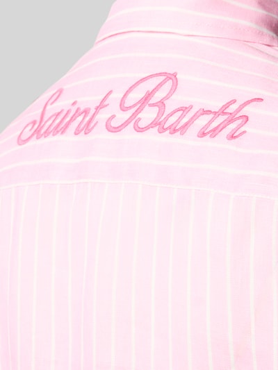 Frauenmodel trägt Leinenbluse mit rückseitigem Logo-Stitching Modell 'MEREDITH' von MC2 Saint Barth in Rosa mit feinen weißen Streifen, Nahaufnahme Rückenpartie. Damen Leinenbluse, reine Leinen, Loose-Fit, Hemdblusenkragen, Knopfleiste, Logo-Stitching.