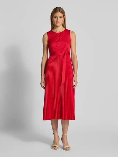 Modelka kobieca ma na sobie czerwone Cocktailkleid mit Plisseefalten von Vera Mont, krój dopasowany, długość midi, okrągły dekolt, drapowania, pasek w talii, plisowane fałdy, zamek z tyłu, długość pleców w rozmiarze 36: 126 cm, szerokość w rozmiarze 36: 30 cm; widok całej sylwetki z przodu
