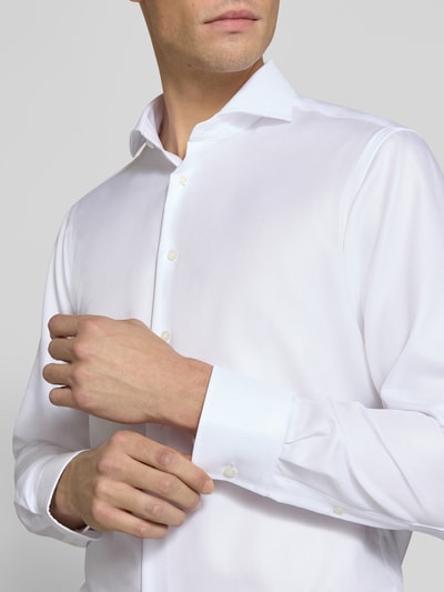 Männermodel trägt Slim Fit Business-Hemd aus reiner Baumwolle von Christian Berg Men, Haikragen, weiße Farbe, Nahaufnahme Oberkörper.