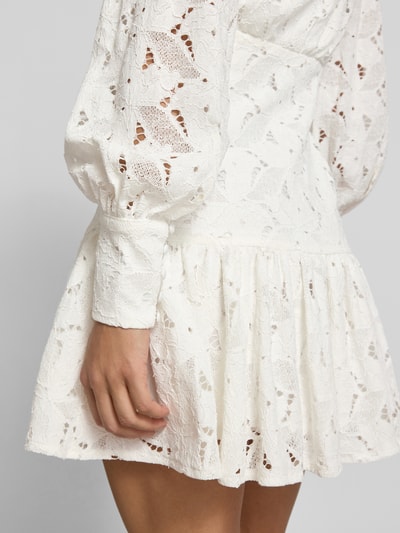 Frauenmodel trägt Cocktailkleid aus Spitze Modell 'REMY' von Bardot im Viskose-Baumwoll-Mix, figurbetonter Schnitt, Minikleid, Knopfleiste, Detailaufnahme.