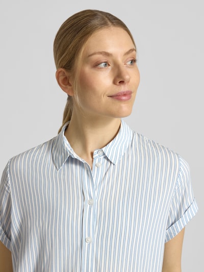Frauenmodel trägt Regular Fit Bluse aus Viskose-Elasthan-Mix Modell 'MAJAN' von Samsøe Samsøe, feine blaue Streifen auf Weiß, Hemdblusenkragen, Kurzarm mit Aufschlag, Allover-Look, Nahaufnahme Oberkörper.
