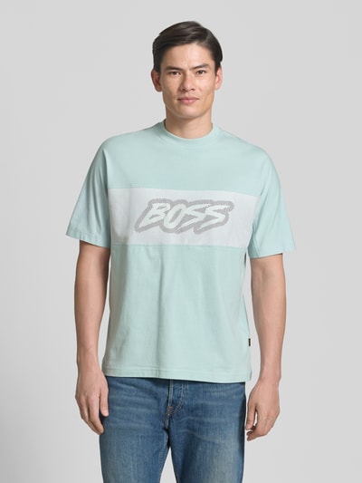 Männermodel trägt Regular Fit T-Shirt aus reiner Baumwolle Modell 'TE_BAYMESH' von BOSS Orange in Hellblau mit Mesh-Details, Ganzkörperansicht von vorne.