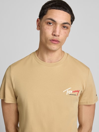 Männermodel trägt Slim Fit T-Shirt aus reiner Baumwolle von Tommy Jeans, Optik: Unifarben, Label-Print, Rundhals, Kurzarm, Nahaufnahme Oberkörper.