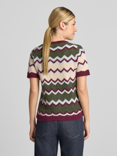 Frauenmodel trägt Strickshirt mit Rundhalsausschnitt von miss goodlife, taillierte Passform, Zickzackmuster in Grün, Creme, Lila, ganzkörperansicht Rückansicht