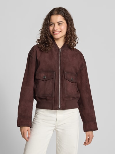 Frauenmodel trägt Regular Fit Leder- / Kunstlederjacke aus echtem Ziegenleder von Marc O'Polo DENIM in Dunkelbraun, glatte Textur, Ganzkörperansicht von vorne.