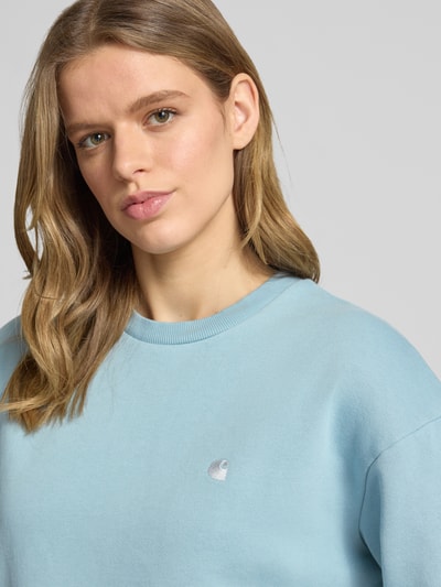 Frauenmodel trägt Sweatshirt mit Logo-Stitching Modell 'CASEY' von Carhartt Work In Progress, Reine Baumwolle, Loose-Fit, Rundhalsausschnitt, überschnittene Schultern, Nahaufnahme Oberkörper.