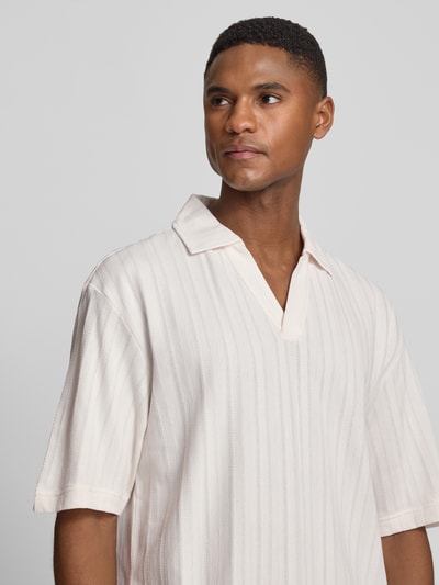Männermodel trägt Relaxed Fit Poloshirt mit Strukturmuster Modell 'DALIBO' von HUGO in Optik: Unifarben, V-Ausschnitt, reine Baumwolle, Nahaufnahme Oberkörper.