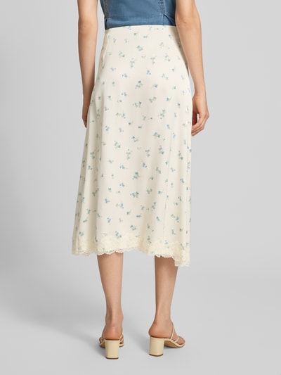 Frauenmodel trägt Ausgestellter Midi-Rock aus reiner Viskose Modell 'SateenSk' von Jake*s Casual, cremefarben mit Blumenmuster, Ganzkörperansicht Rückansicht.