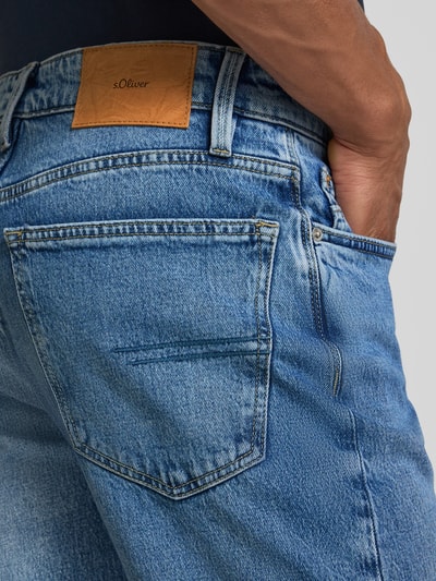 Mężczyzna nosi Regular Fit Straight Jeans aus Baumwoll-Mix Modell 'BENITO' von s.Oliver RED LABEL, zbliżenie tylnej kieszeni.