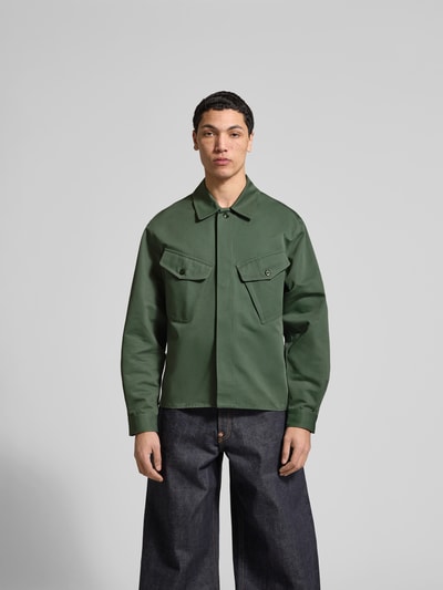Männermodel trägt Regular Fit Hemdjacke aus Baumwolle von Kenzo in Grün, Umlegekragen, Brusttaschen, verdeckte Knopfleiste, Ganzkörperansicht von vorne. Rückenlänge bei Größe M: 70 cm.