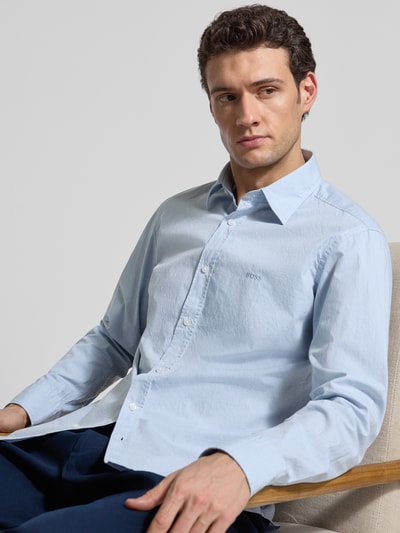 Männermodel trägt Regular Fit Freizeithemd aus Baumwoll-Mix Modell 'RELEGANT_6_M' von BOSS Orange in Hellblau, Nahaufnahme Oberkörper.