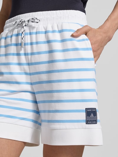 Frauenmodel trägt Shorts mit Label-Detail und Tunnelzug von Marc Cain, Baumwoll-Mix mit Modal-Anteil, Regular-Fit, Nahaufnahme Oberschenkel.