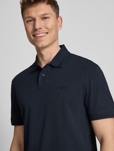 Männermodel trägt Regular Fit Poloshirt aus reiner Baumwolle Modell 'INTERLOCK' von BOSS Orange, Optik: Unifarben, Nahaufnahme Oberkörper.