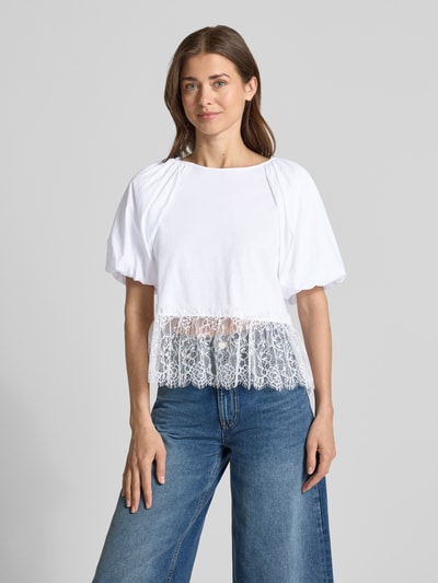Frauenmodel trägt T-Shirt mit Spitze und Ballonärmeln von Rich & Royal in Weiß, Reine Baumwolle, Straight Fit, Rundhalsausschnitt, Rückenlänge 56 cm bei Größe S, Ganzkörperansicht von vorne.