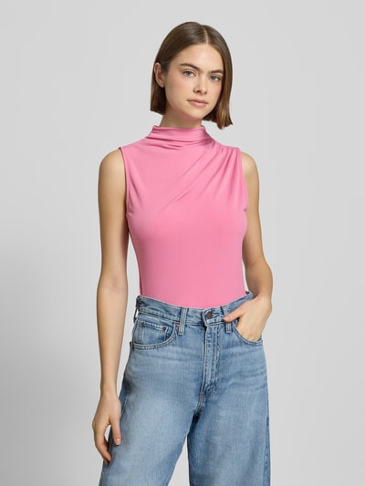 Frauenmodel trägt Shaped Fit Shirt ohne Ärmel Modell 'MADISON' von Pieces in Rosa, unifarben, hochgeschlossen, Label Stitching, Ganzkörperansicht von vorne