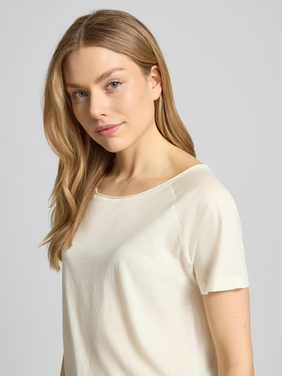 Vrouwenmodel draagt T-Shirt met U-Boot-hals model 'LALOOM' van American Vintage, pure katoen, relaxed fit, licht crème, close-up bovenlichaam.