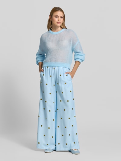 Frauenmodel trägt sommerlicher cropped Strickpullover - curated by Mary Braun von Style Icon Collection in Strick-Optik, Relaxed-Fit, Rundhalsausschnitt, elastische Abschlüsse, Rückenlänge bei Größe S 53 cm, Ärmellänge bei Größe S 72 cm, zartes Hellblau mit transparenter Textur, Ganzkörperansicht von vorne.