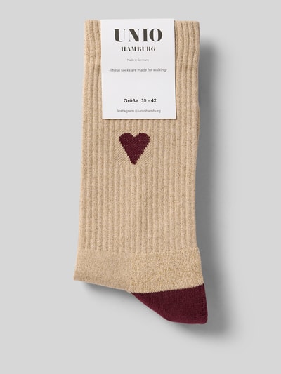 Produktfoto, Socken mit Label-Print von Unio aus Baumwoll-Metall-Mix mit Stretch-Anteil, körpernaher Schnitt, gerippter Abschluss, beige mit bordeauxfarbenem Detail, Label-Print von Unio sichtbar.
