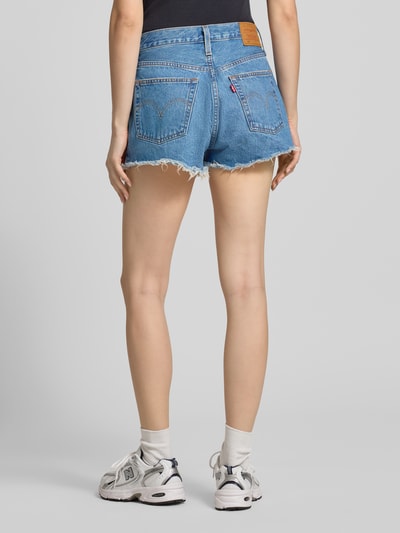 Kobiece model nosi szorty jeansowe z 5 kieszeniami od Levi's®, tkanina stylizowana na denim, krój slim fit, czysta bawełna, zapięcie z ukrytą listwą guzikową, widok całej sylwetki z tyłu.