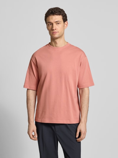Männermodel trägt Relaxed Fit T-Shirt aus reiner Baumwolle Modell 'RELEXASPEN' von SELECTED HOMME, unifarben, Feinripp, Ganzkörperansicht von vorne.