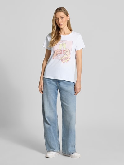 Kobiece model prezentuje T-Shirt aus reiner Baumwolle Modell 'CLINK EASY TEE' od Guess, biały, prosty krój, okrągły dekolt, przód, ujęcie całej sylwetki.