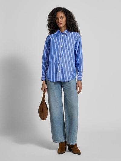 Modelka nosi Relaxed Fit Bluse mit Brusttasche von Gant, niebiesko-białe paski, bawełna, kołnierzyk, kieszonka; widok całej sylwetki z przodu