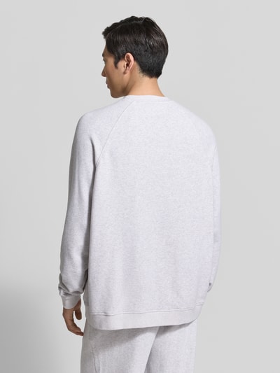 Männermodel trägt Sweatshirt mit Rundhalsausschnitt Modell 'ATUBAY' von American Vintage aus Baumwoll-Elasthan-Mix in Hellgrau, Relaxed-Fit, Rückenansicht, Kontext: Herren Sweatshirt, Rückenlänge bei Größe M/L 67 cm, Ärmellänge 77 cm.
