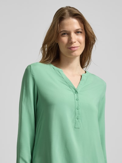 Frauenmodel trägt Regular Fit Bluse aus reiner Viskose mit Tunika-Ausschnitt von Christian Berg Woman, Knopfleiste, langärmelig, mintgrün, Nahaufnahme Oberkörper.