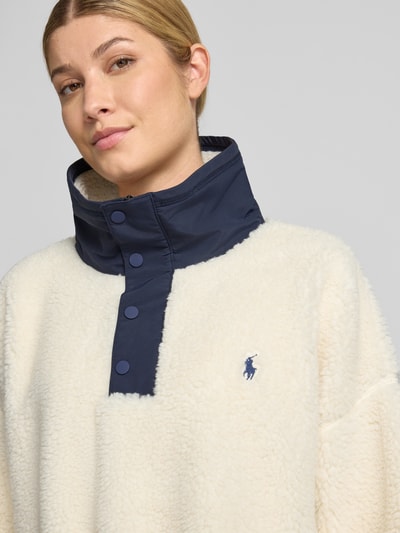 Frauenmodel trägt Oversized Sweatshirt mit Polo-Bear-Intarsie von Polo Ralph Lauren, cremefarben mit dunkelblauen Details, Nahaufnahme Oberkörper, Damen Sweatshirt von Polo Ralph Lauren