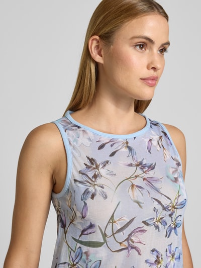 Frauenmodel trägt Top im Allover-Look mit Rundhalsausschnitt von Marc Cain, Baumwoll-Mix, florales Muster, Nahaufnahme Oberkörper.