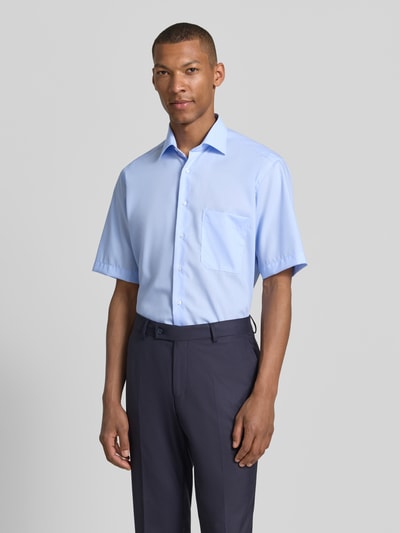 Männermodel trägt hellblaues Relaxed Fit Freizeithemd im kurzärmeligen Design von ETERNA aus reiner Baumwolle, Ganzkörperansicht von vorne.
