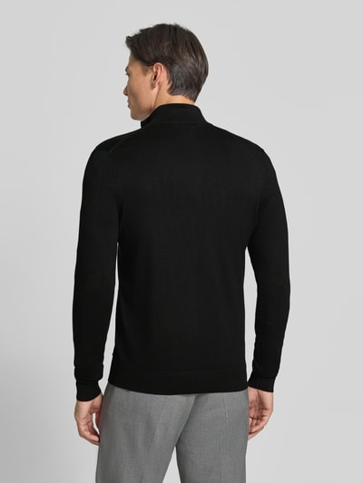 Männermodel trägt Troyer mit Label-Applikation von MARKUP, schwarzer Viskose-Mix, gerader Schnitt, Rückansicht, Ganzkörperansicht Rückansicht.