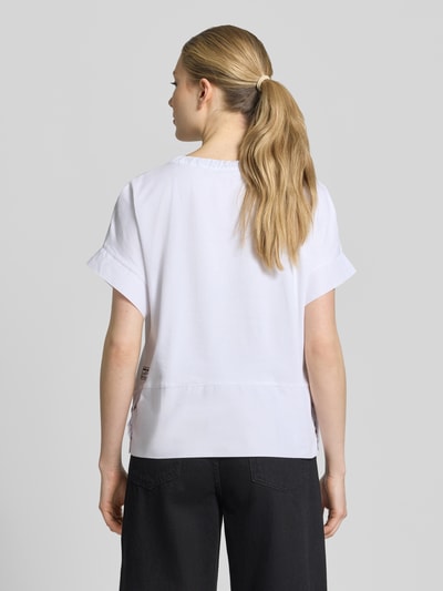Modelka nosi T-Shirt mit Tunikakragen und Kordelzug von Marc Cain, mieszanka bawełny z dodatkiem streczu, prosty krój, detale z logo, damski t-shirt, długość tyłu w rozmiarze 36: 55 cm, widok całej sylwetki z tyłu.