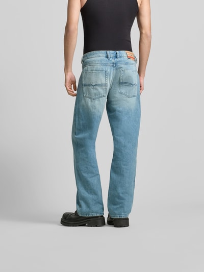 Männermodel trägt Flared Fit Jeans mit Logo-Patch von Diesel in Hellblau, 5-Pocket-Design, reine Baumwolle, Ganzkörperansicht Rückansicht.